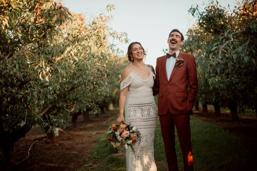 Laughing couple in an orchard.