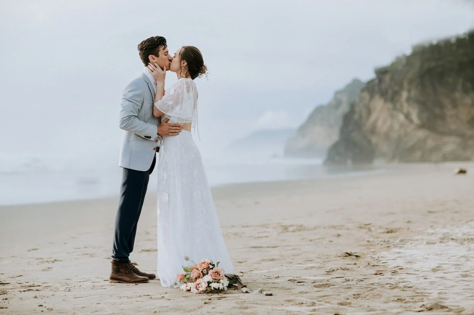 Couple kisses on Torrey Pines beach in San Diego after their Courthouse wedding.