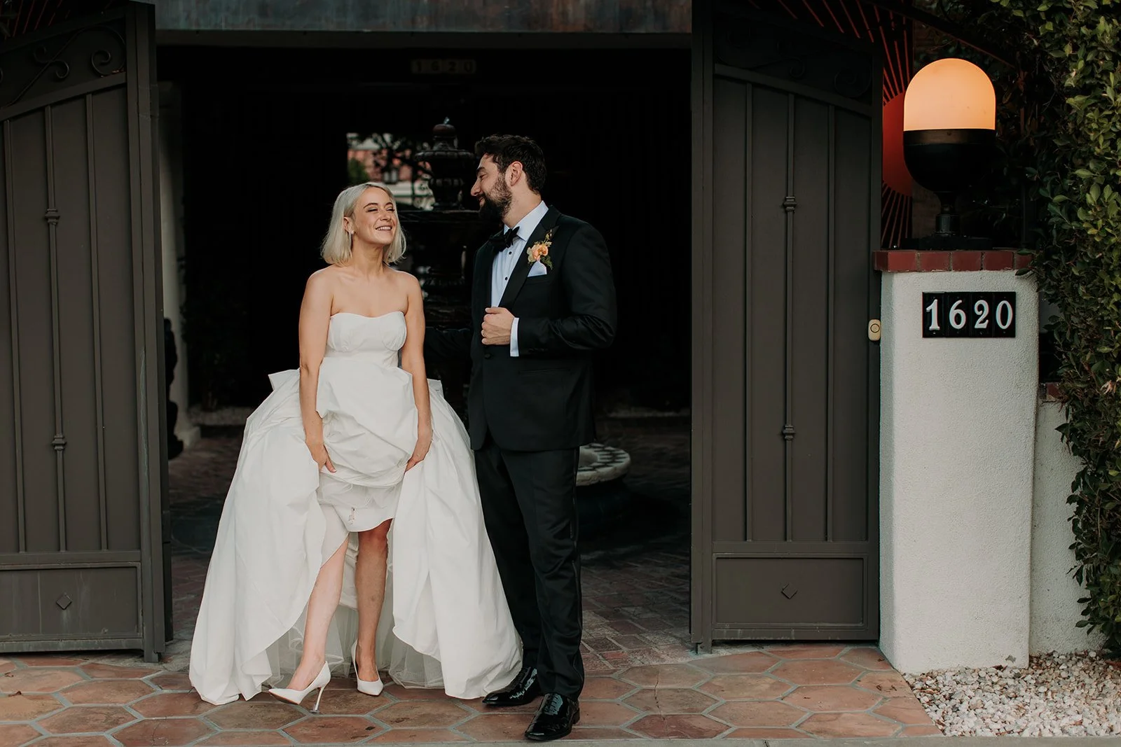 Candid photo of bride showing her groom her shoes at their wedding at Villa Royale in Palm Springs.
