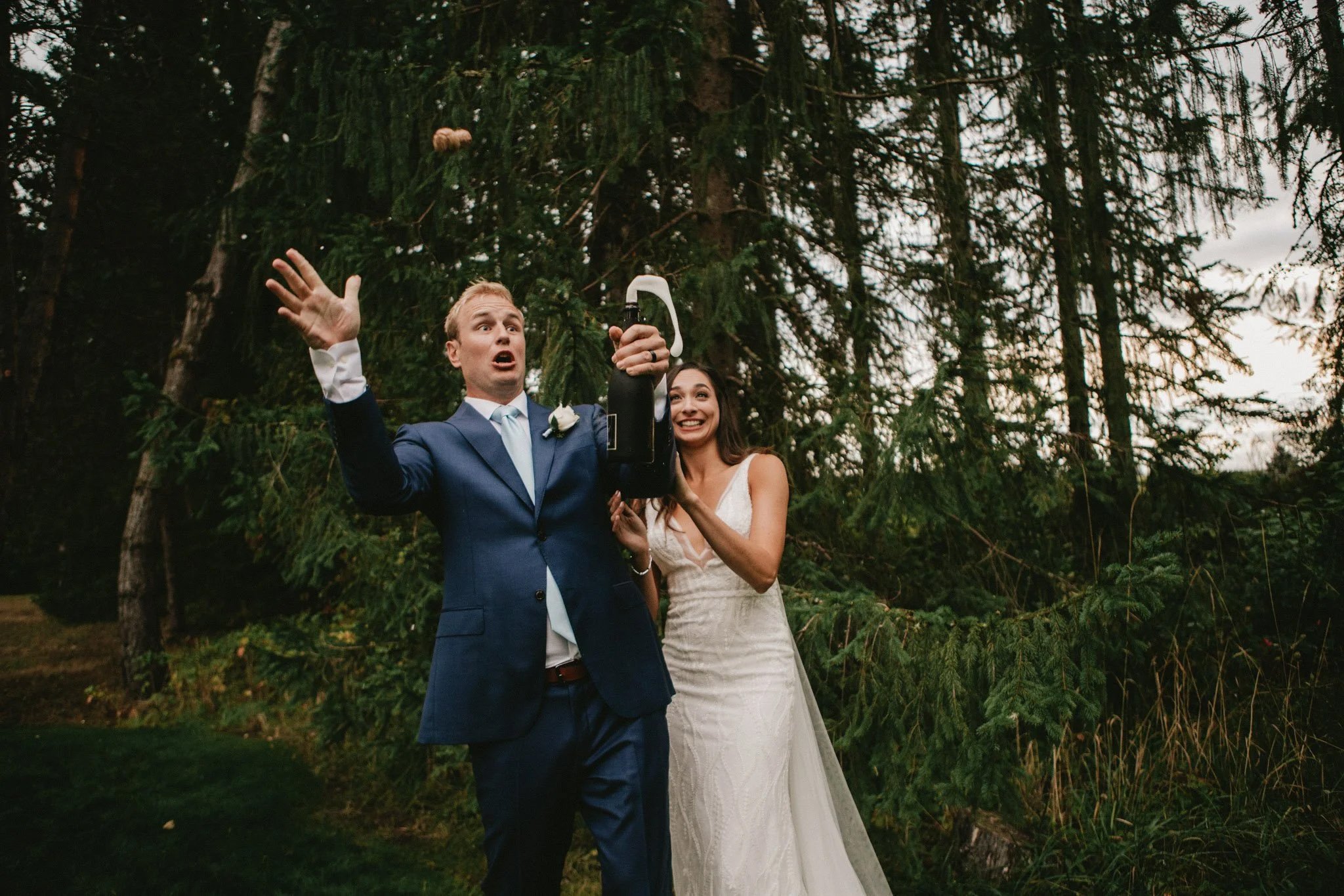 A groom pops a champagne bottle at their San Diego wedding.