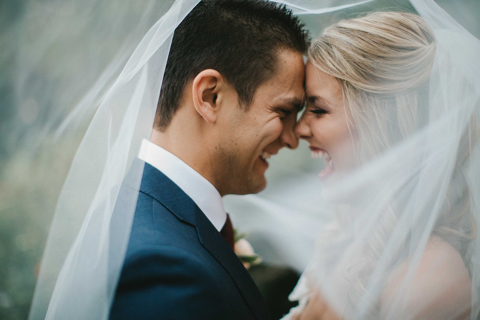 Bride and groom laugh under her wedding veil after their San Diego courthouse wedding elopement. San Diego courthouse wedding photographer. 