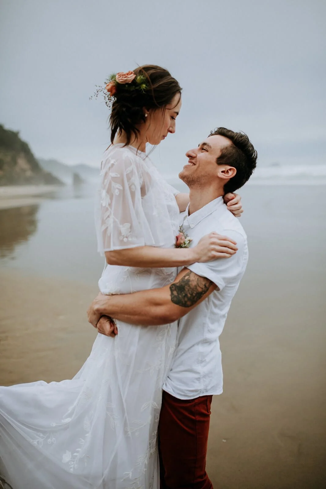 Groom lifts happy bride for their San Diego beach wedding photography.
