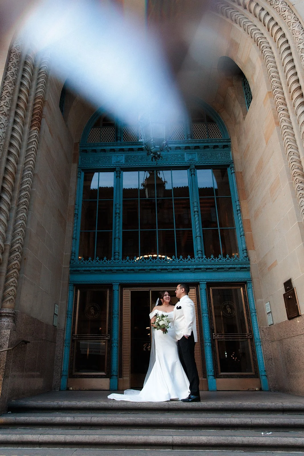 Gaslamp wedding portrait of bride and groom in front of mid century building. 