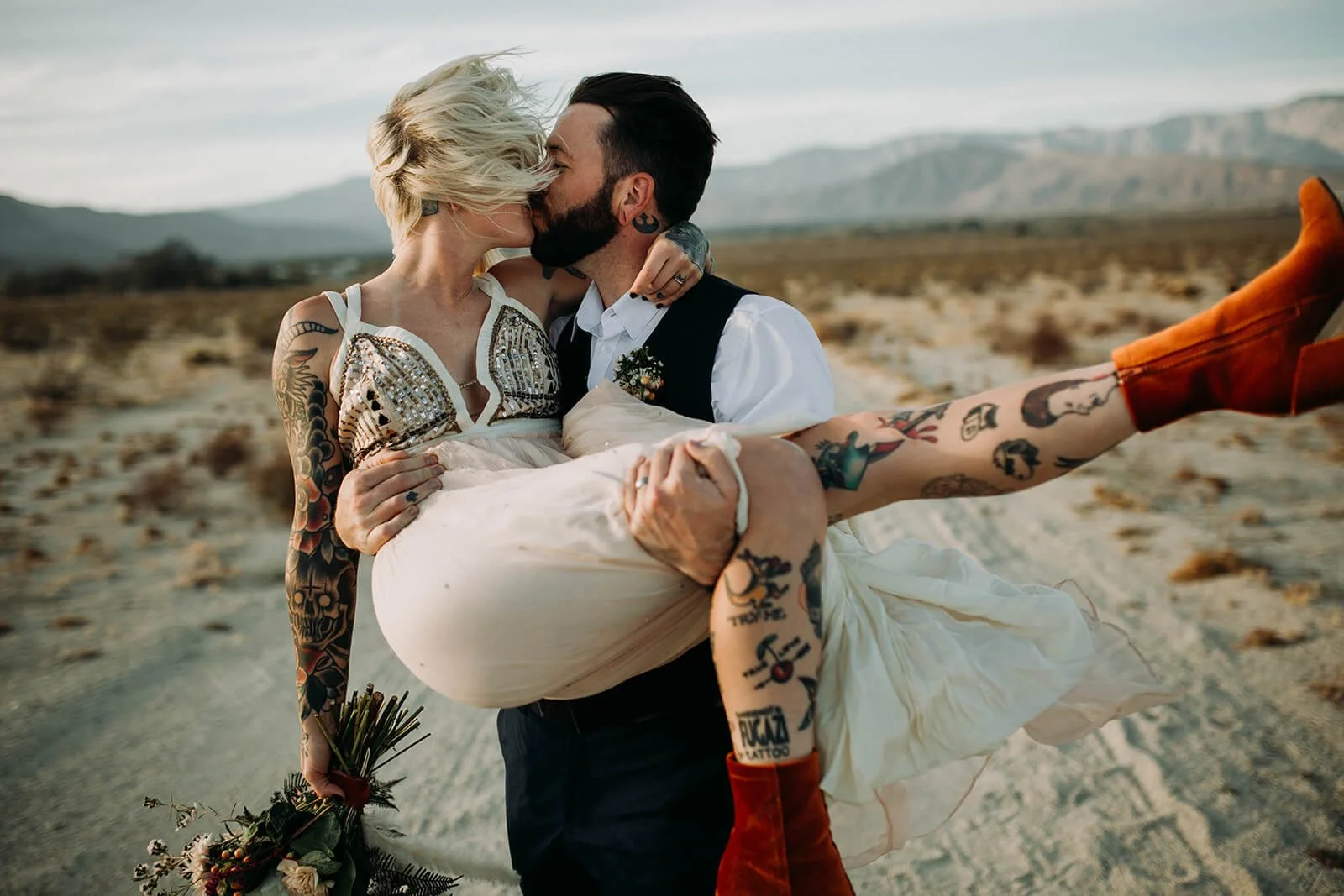 Groom lifts and kisses his bride for their San Diego wedding.