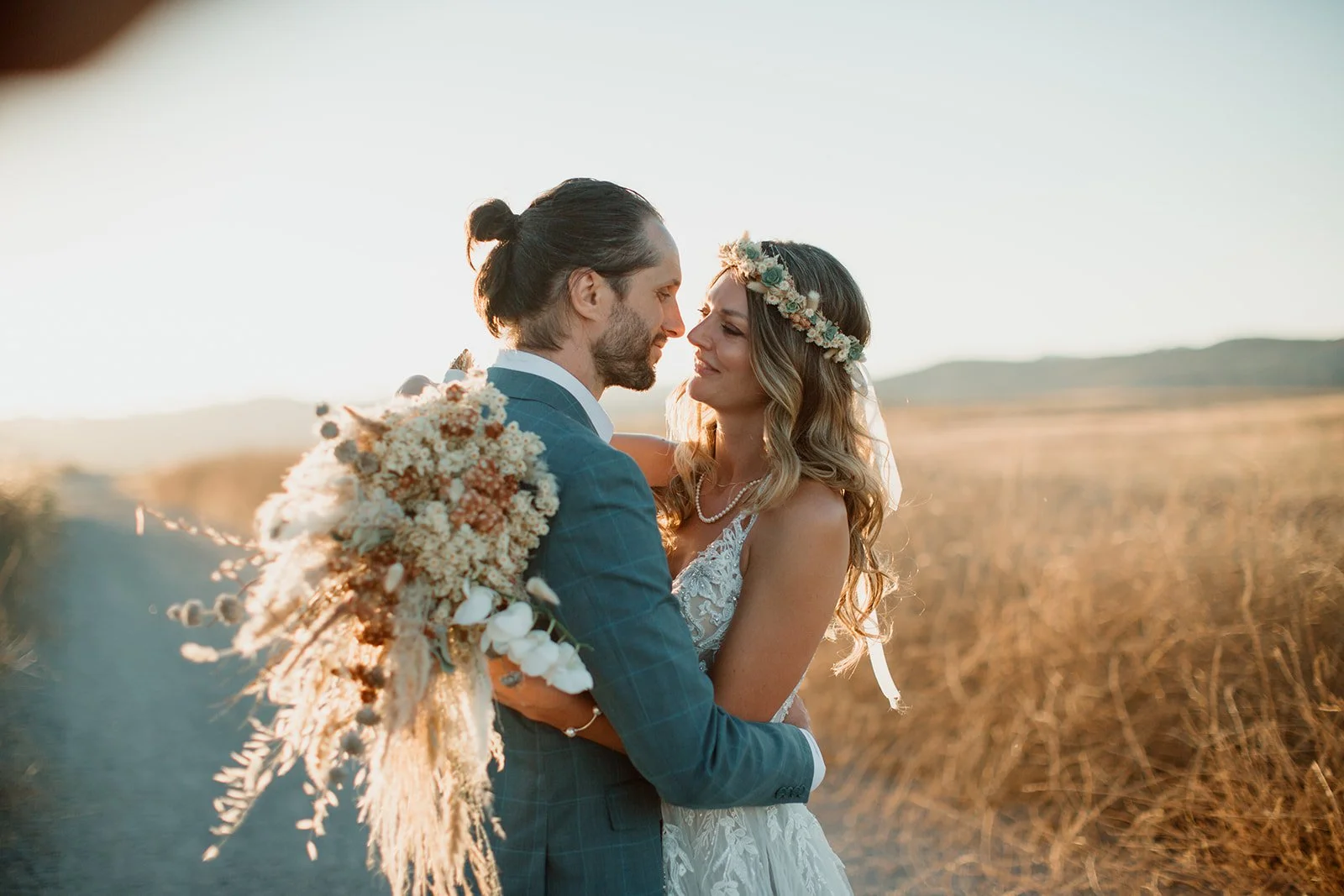 Sunset photos of a bride and groom embracing at their San Diego wedding.