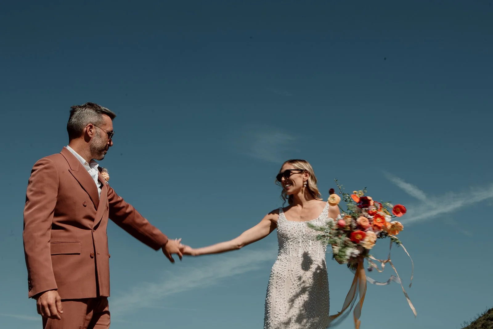 San Diego courthouse photography. Couple happily smiles at each other while holding hands.