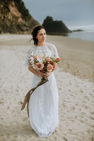 A beautiful bride stands on a beach in San Diego for her elopement wedding day.