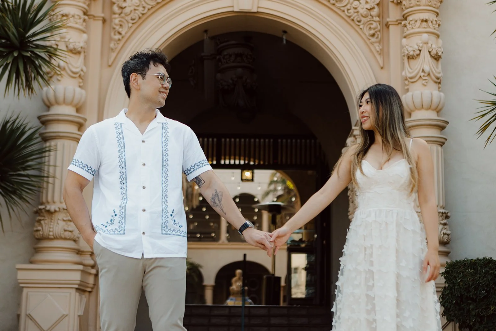 Bride and groom to be hold hands in Balboa Park after their proposal photos.