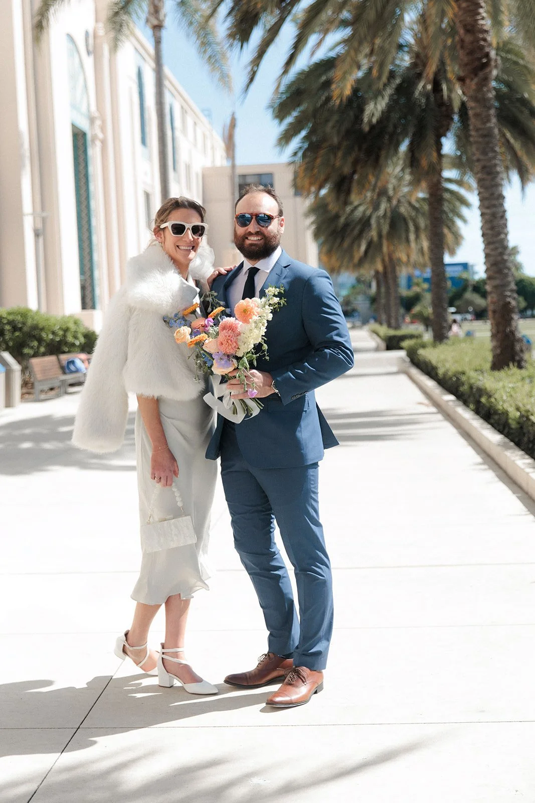 Couple stands outside the San Diego Courthouse after their wedding ceremony.
