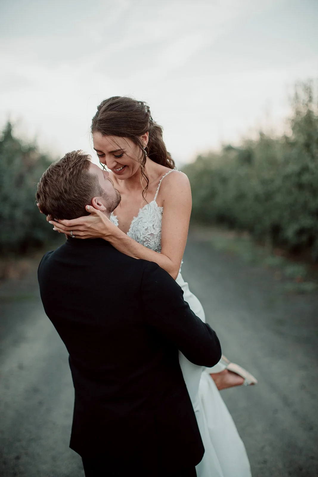 Groom lifts his bride at their San Diego wedding.