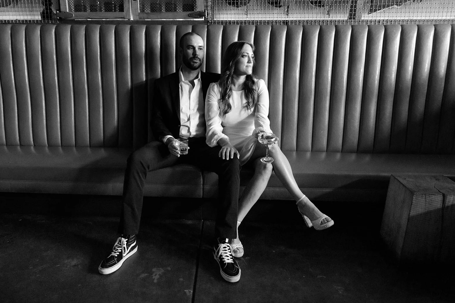 San Diego engagement photo of a couple seated in a bar having cocktails.