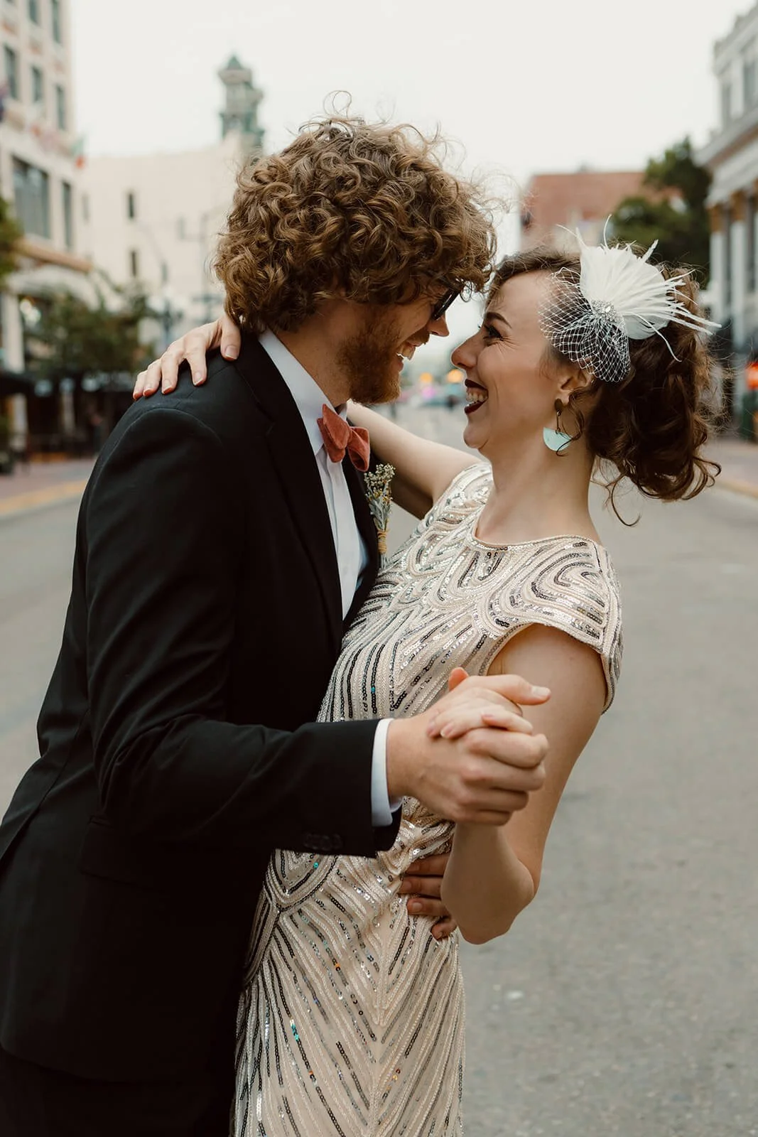 Groom embraces bride in the Gaslamp downtown San Diego for their San Diego courthouse wedding photos. 
