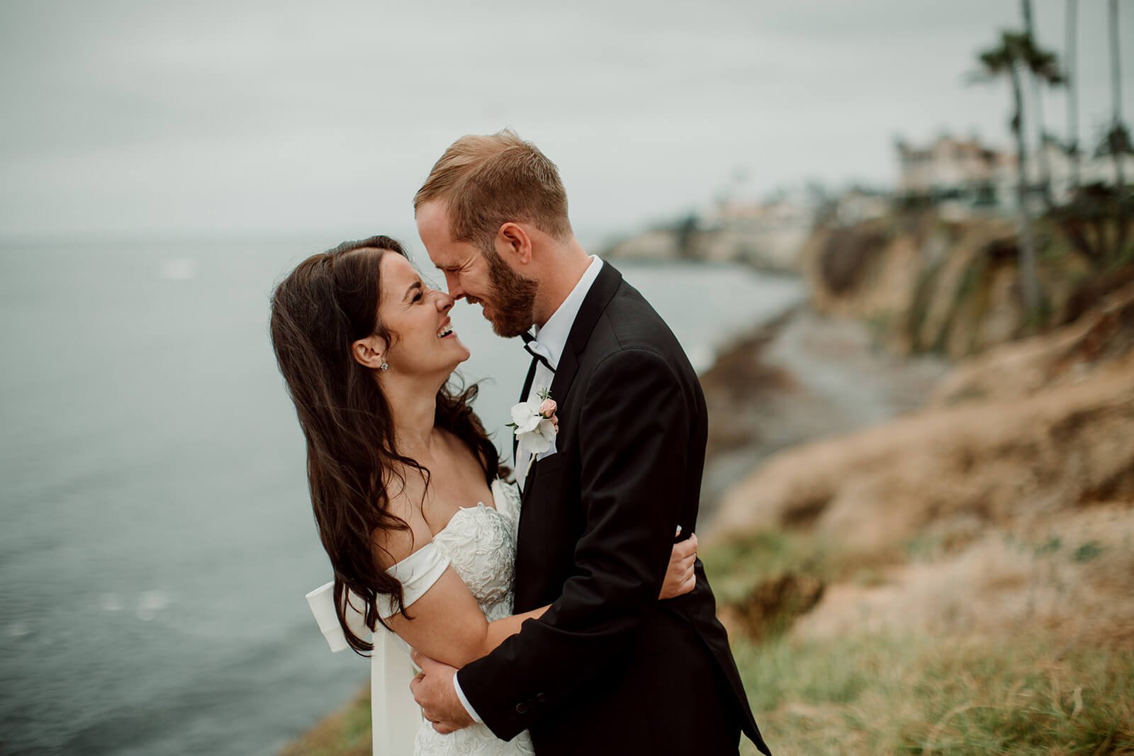 Couple smiling for their beach portraits following their San Diego Courthouse wedding.