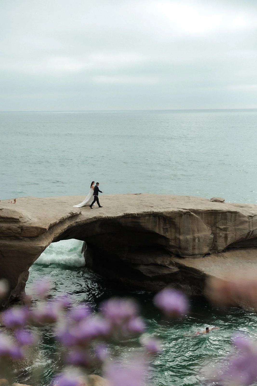 Bride and groom walk down to the an ocean overlook during their San Diego wedding.
