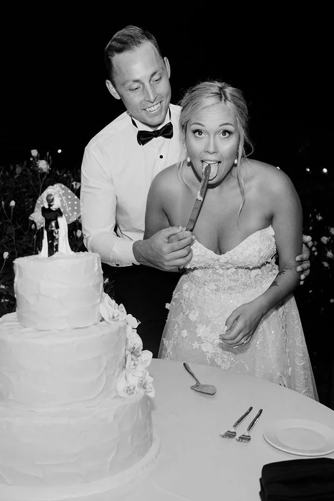Bride licks the knife while cutting her wedding cake at her La Jolla wedding in San Diego.
