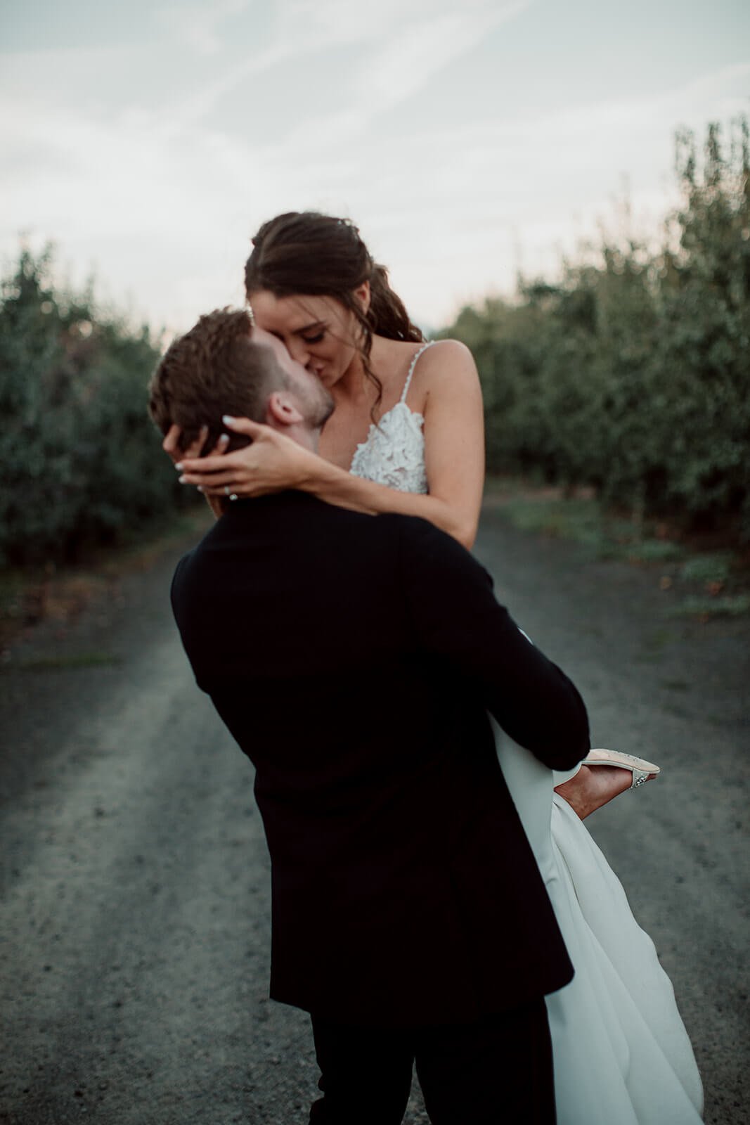 San Diego wedding photographer captures groom picking up and kissing his bride.