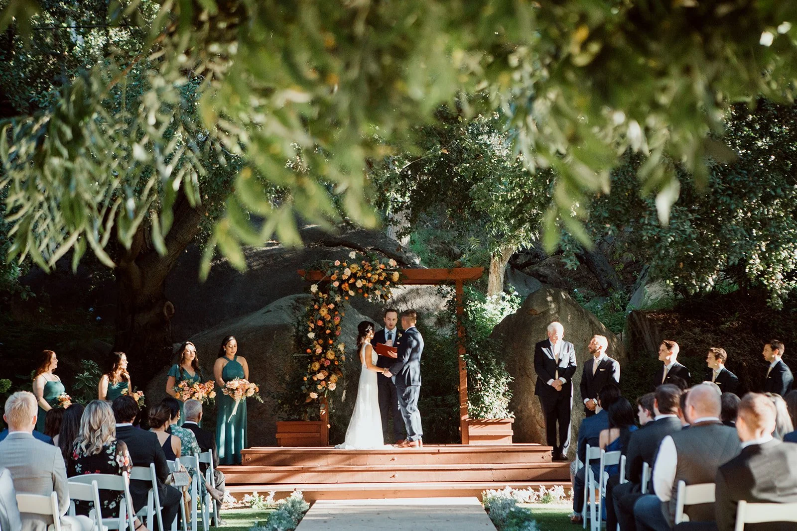 Bride and groom stand with their wedding party during a wedding Ceremony at Temecula Creek Cottages.