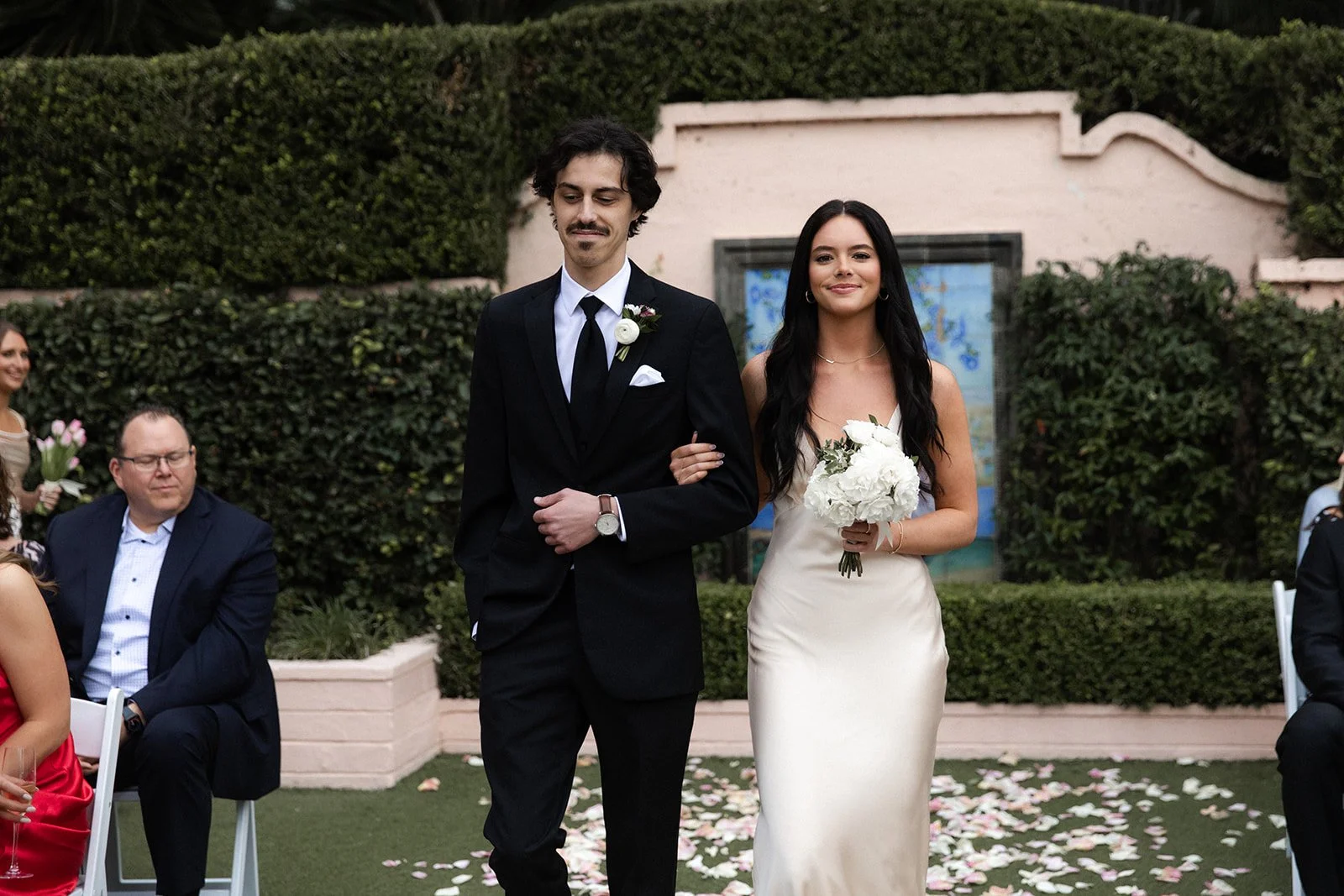 Best man and. maid of honor walk down the isle for a San Diego wedding at La Valencia Hotel.