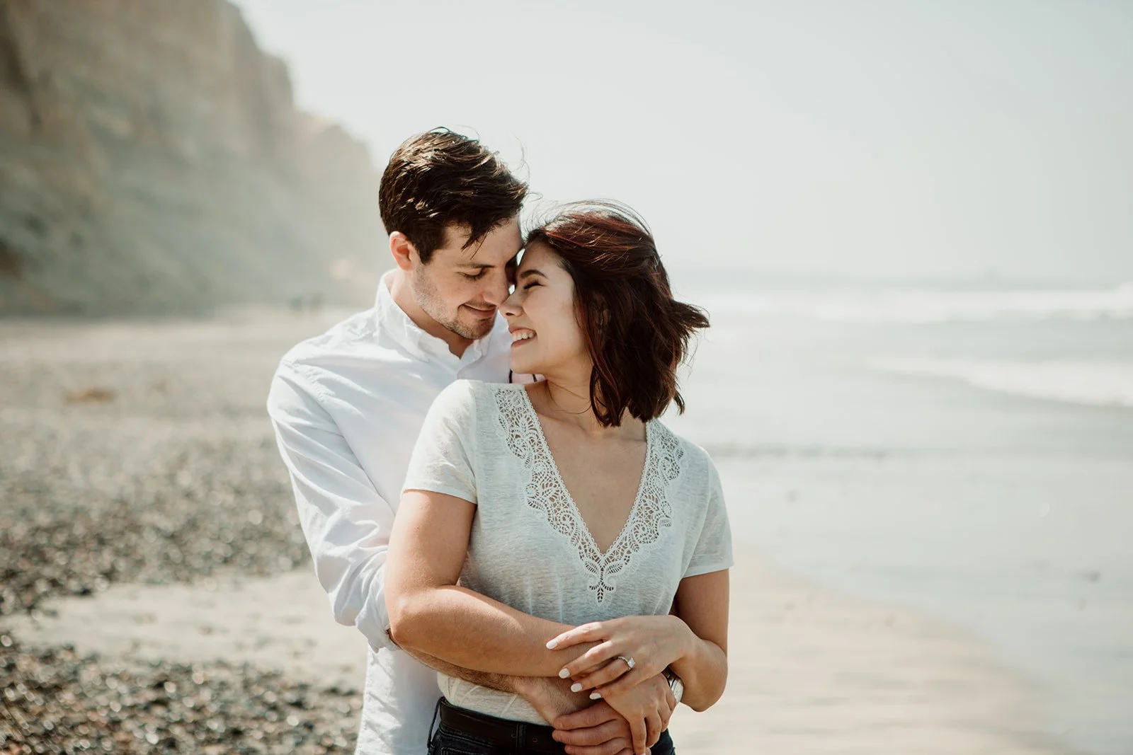 Beach San Diego engagement photo of a happy couple embracing at Torrey Pines.