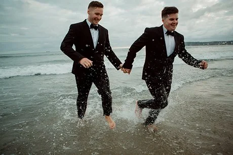 San Diego elopement wedding portraits of couple running in water at Coronado Beach.