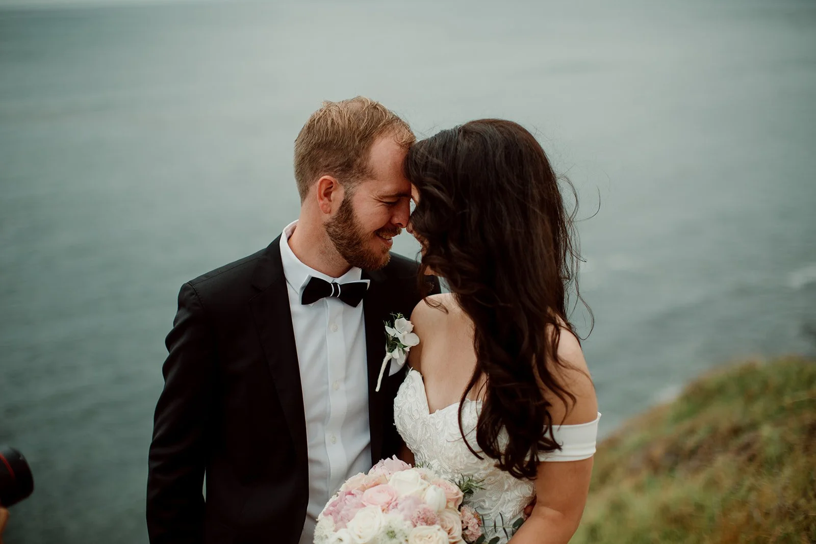 Couple embracing and smiling at their San Diego coastal wedding in La Jolla.