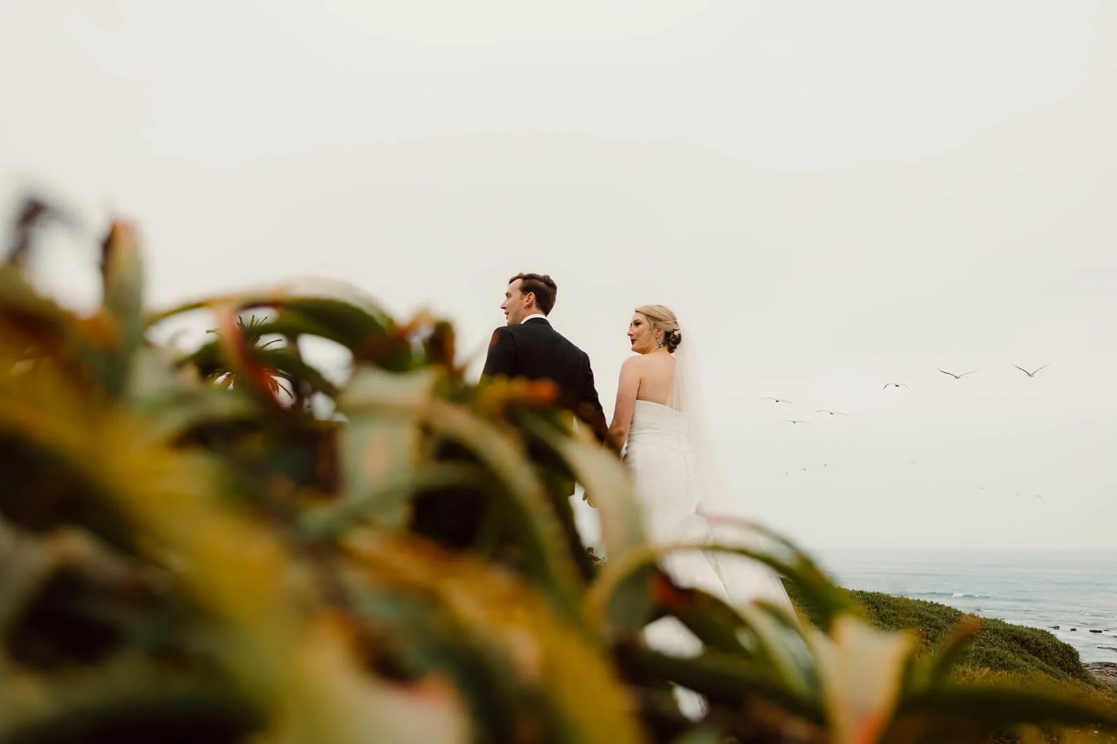 San Diego couple walking near ocean after their ceremony.