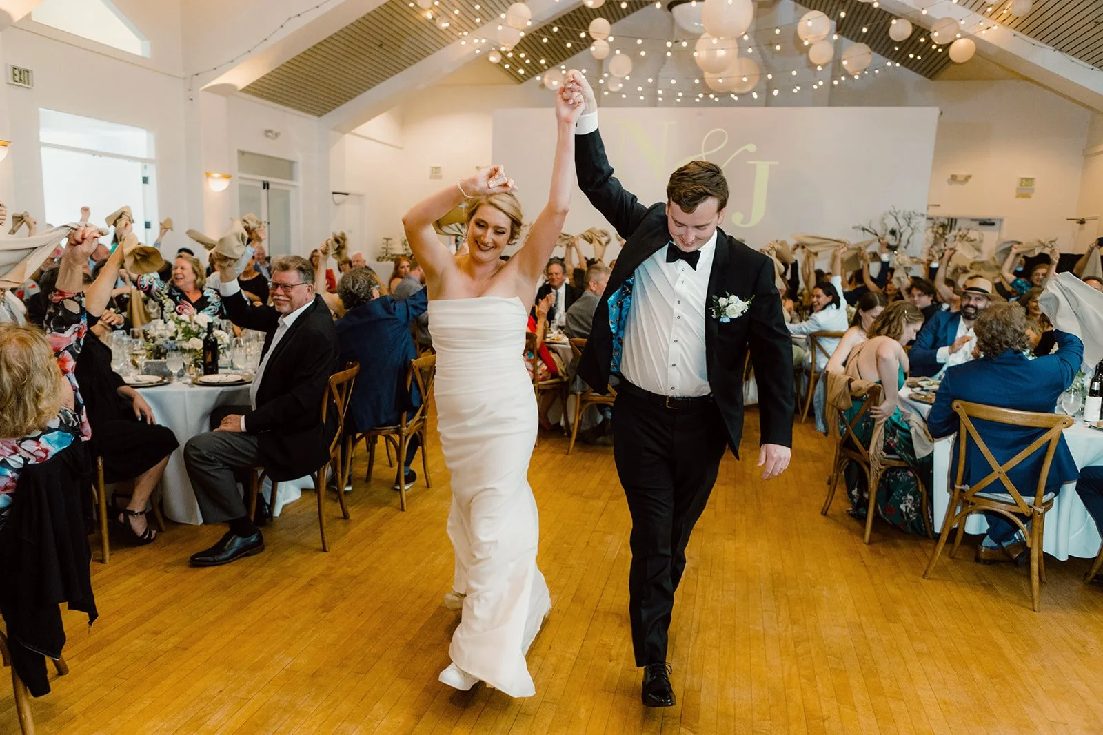 San Diego wedding at Cuvier Club in La Jolla. Couple enters their festive reception.