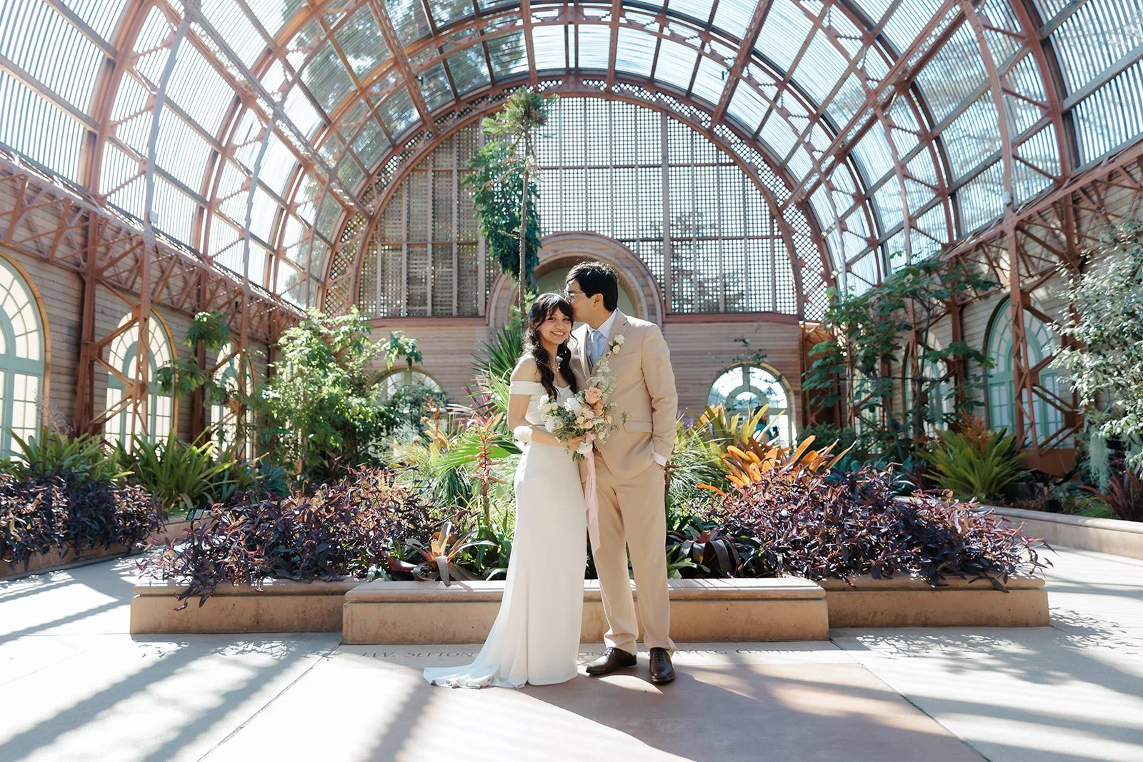 Couple has their portraits taken in the Balboa Park Botanical building.