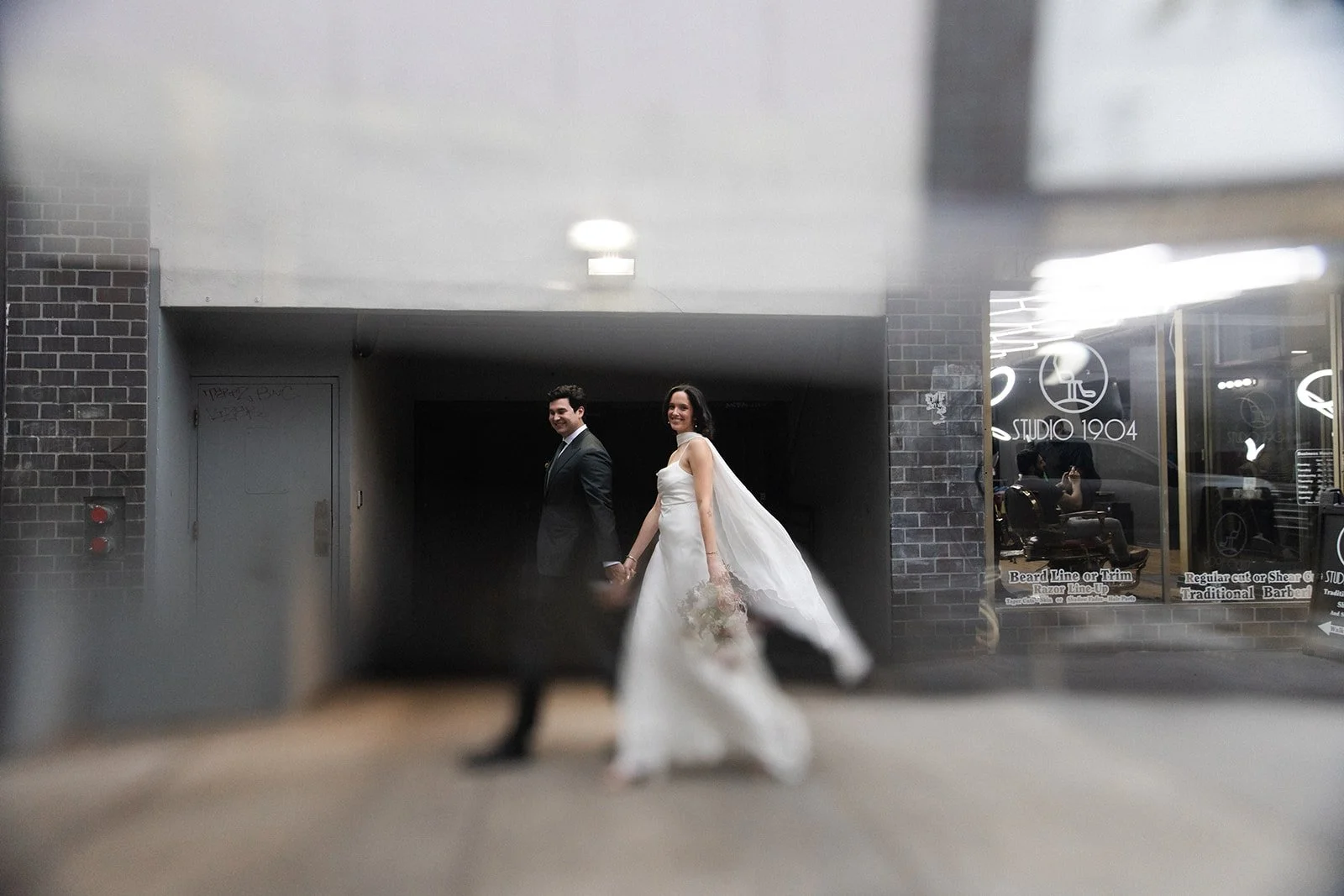 Bride and groom walk in downtown Gaslamp Quarters in San Diego.