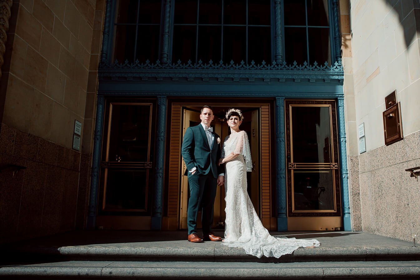 Bride and groom stand in front of downtown building for their San Diego wedding photos. 