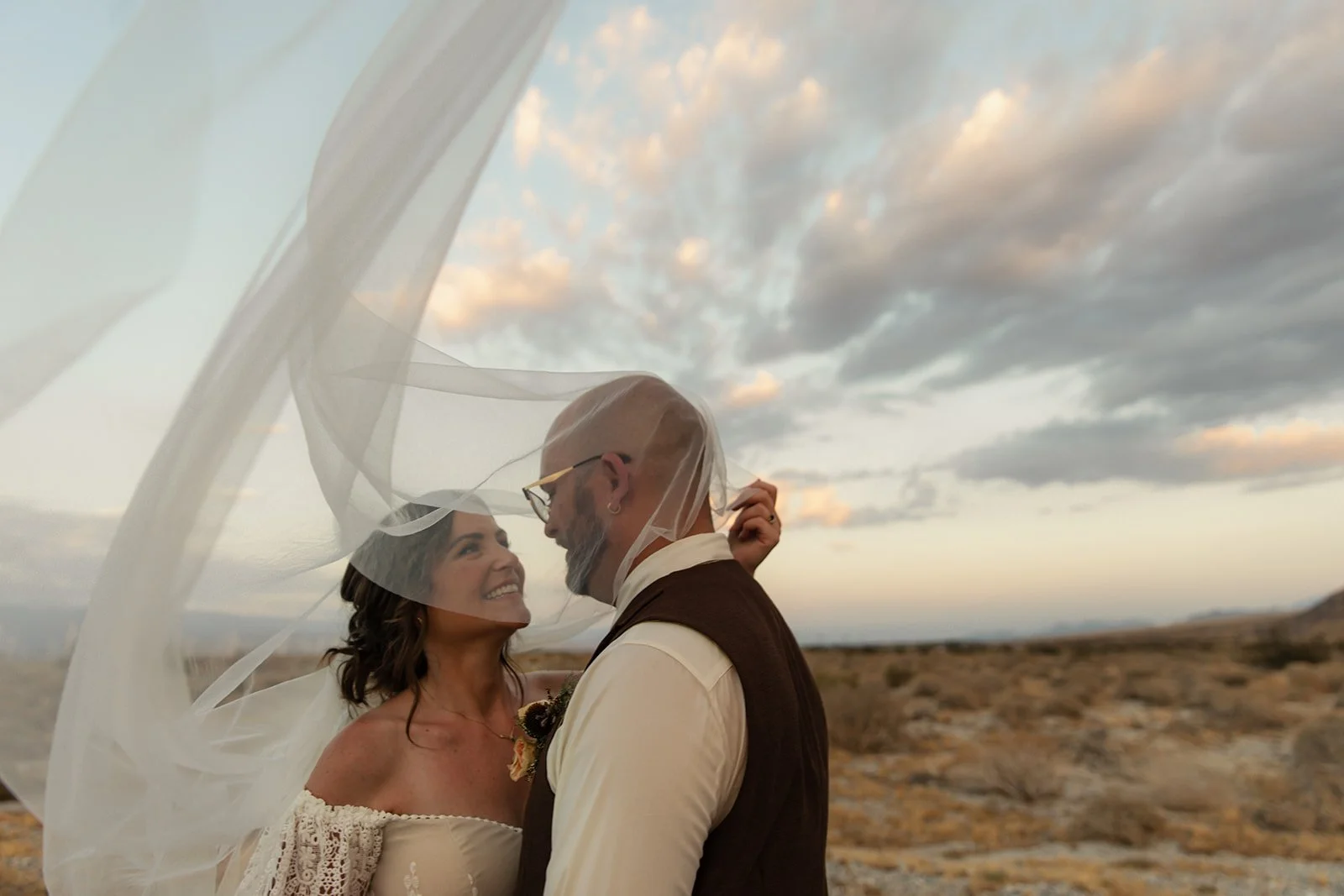 San Diego couple embraces under dramatic sky for their wedding.