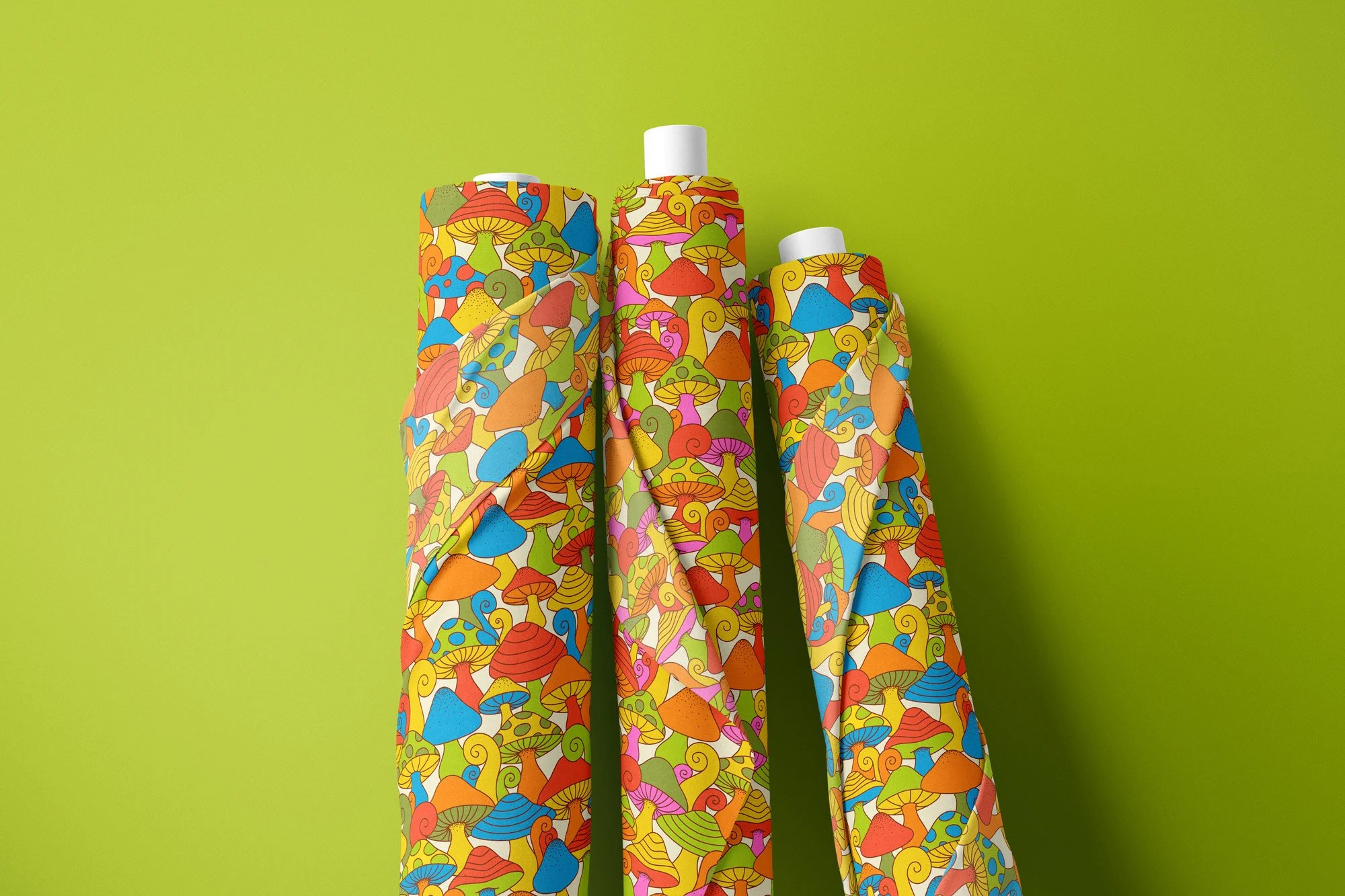 Three rolls of fabric with colorful mushroom patterns against a lime green background.
