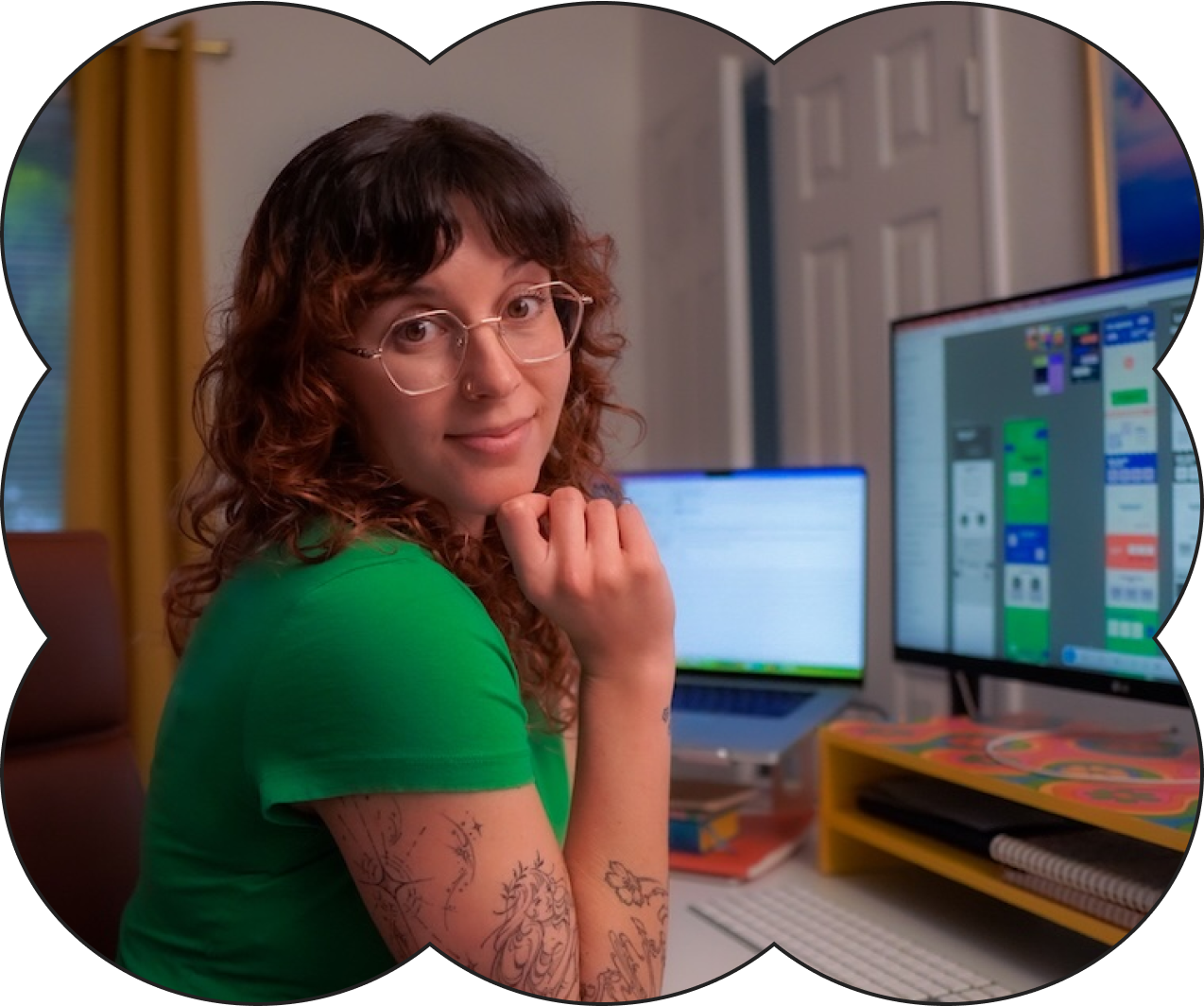 A photo of Jen Webb web designer in front of her computer screen displaying website designs in Figma.