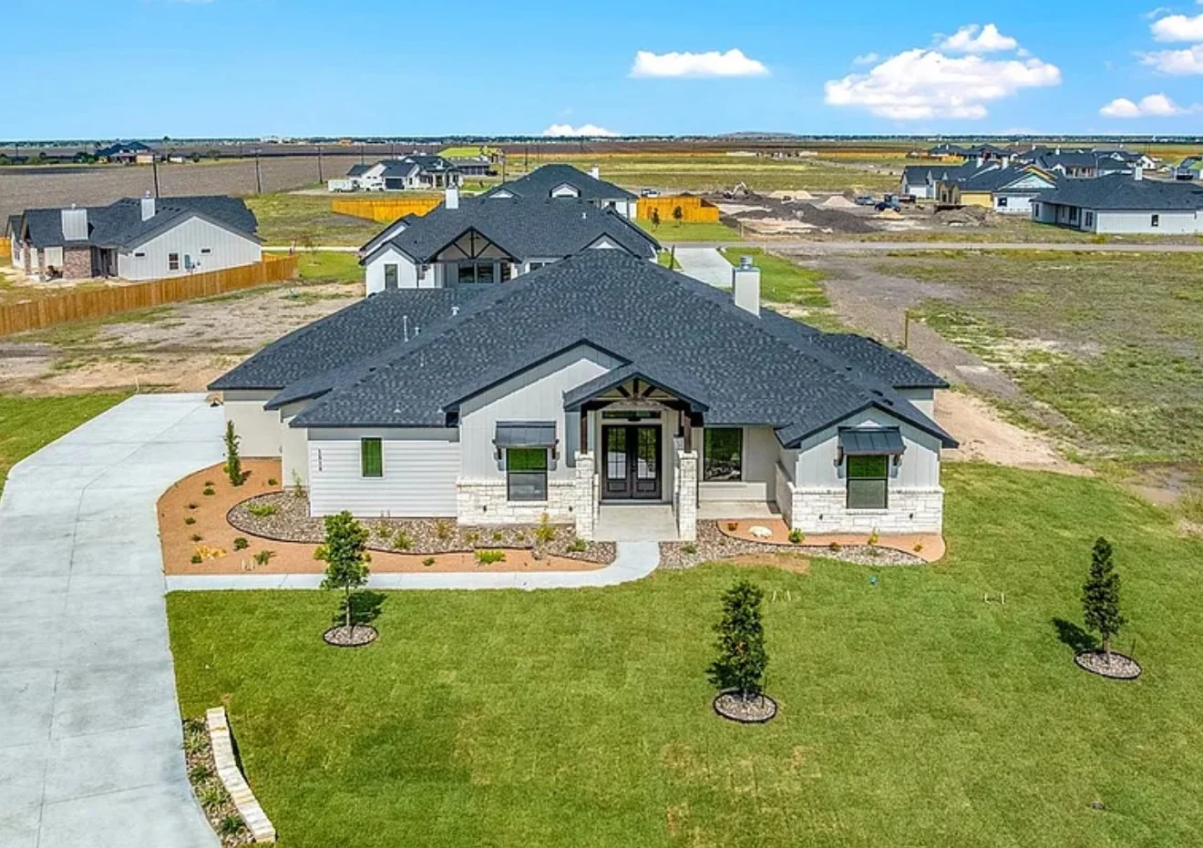 Line drawing of a house with a gabled roof, front porch, and stone accents on the lower walls.