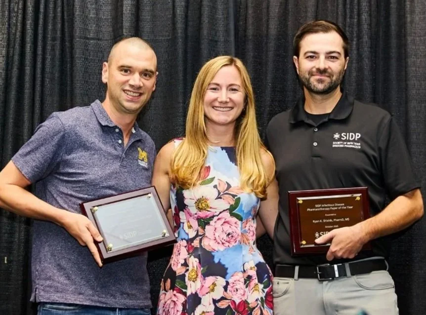Erin McCreary presents SIDP Pharmacotherapy Paper of the Year 2025 award for the CACTUS study to Jason Pogue and Ryan Shields