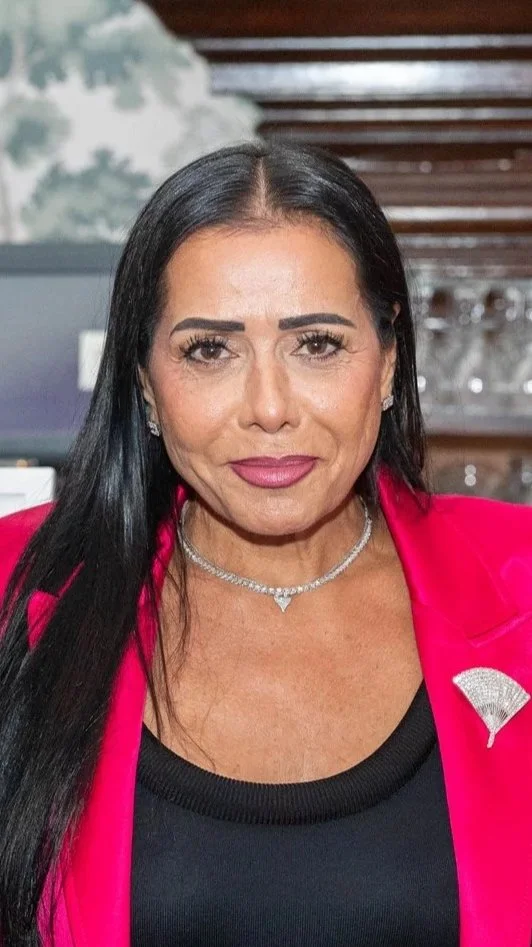 A woman with long dark hair smiling at the camera.