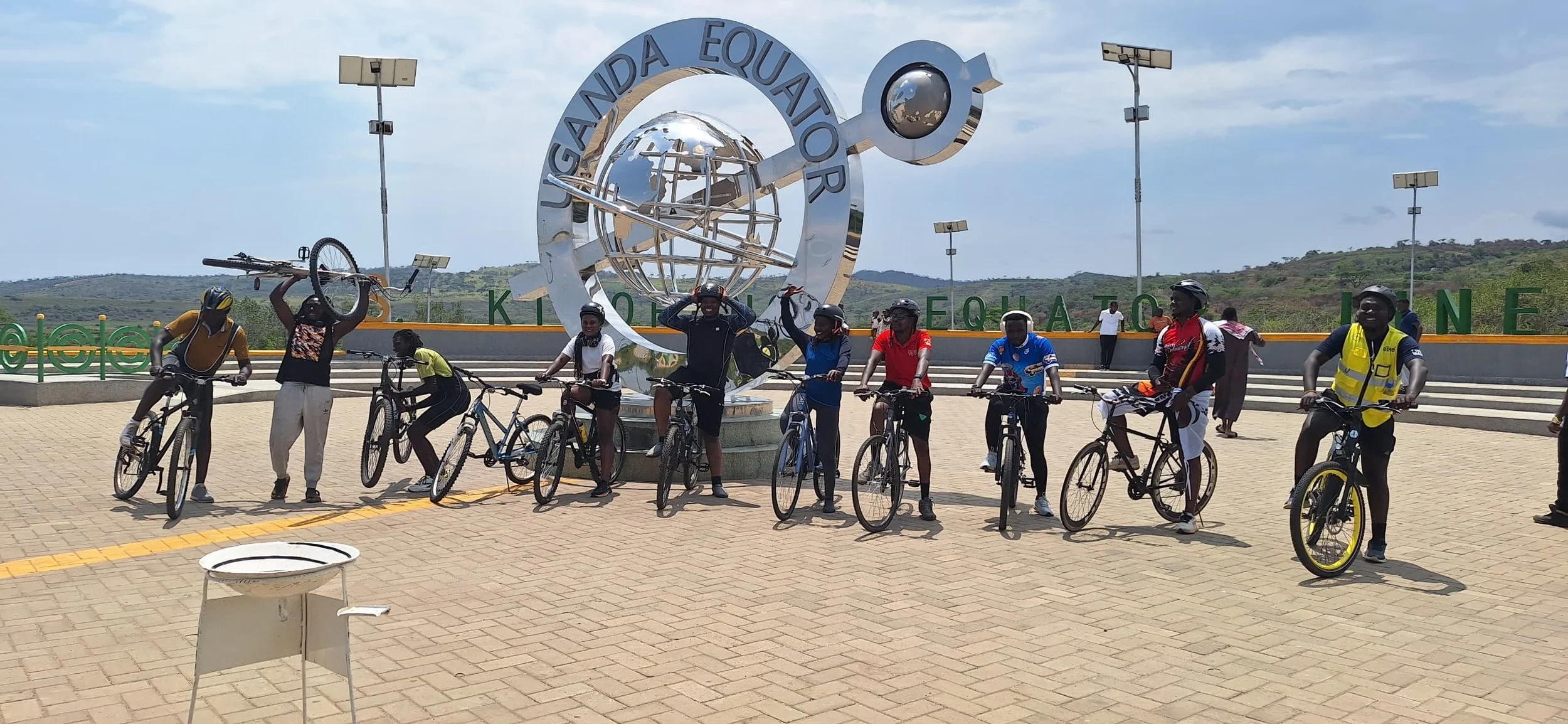 Group of cyclists infront of the the equator monument