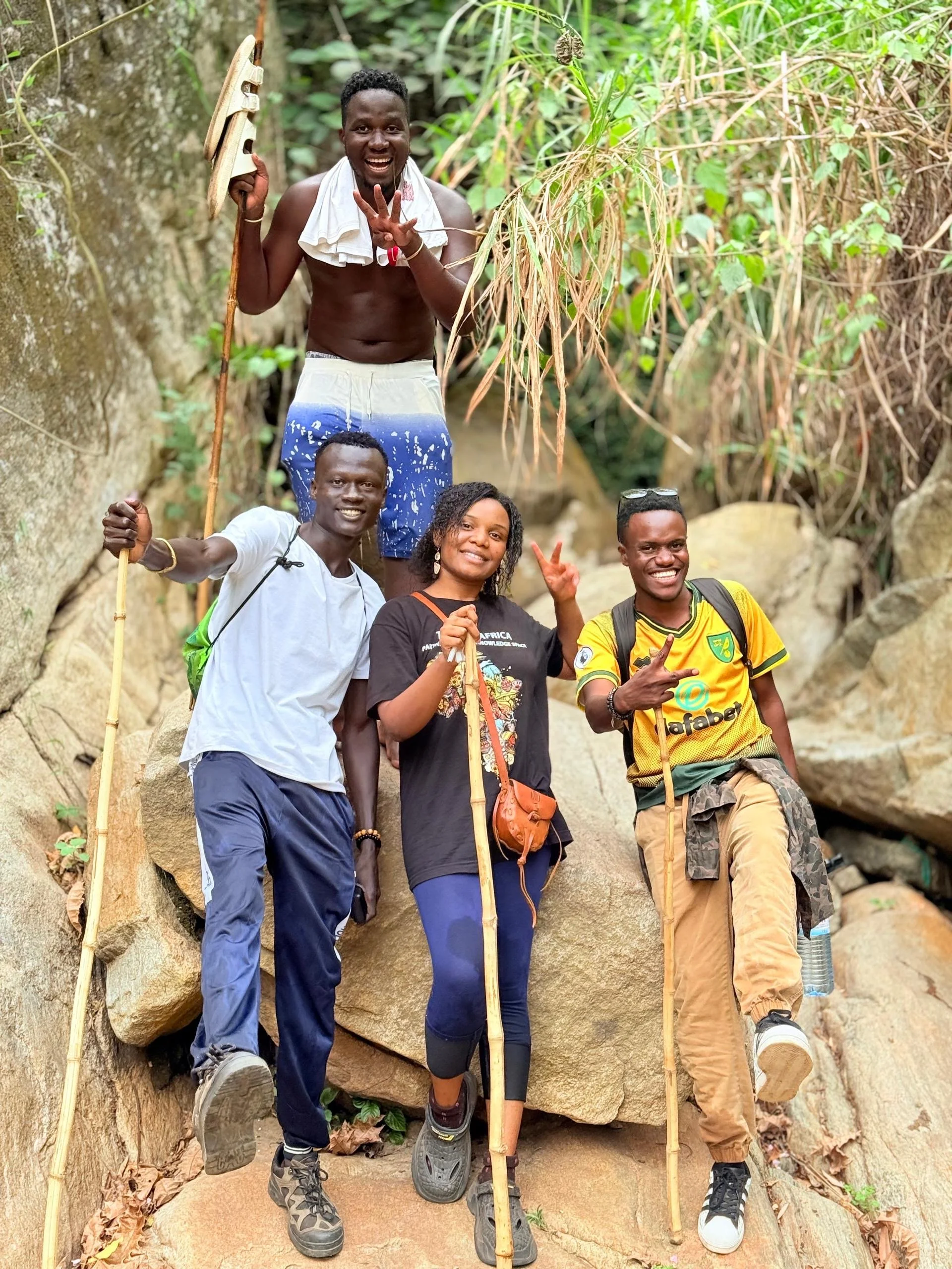 Four hikers with walking sticks smiling at the camera