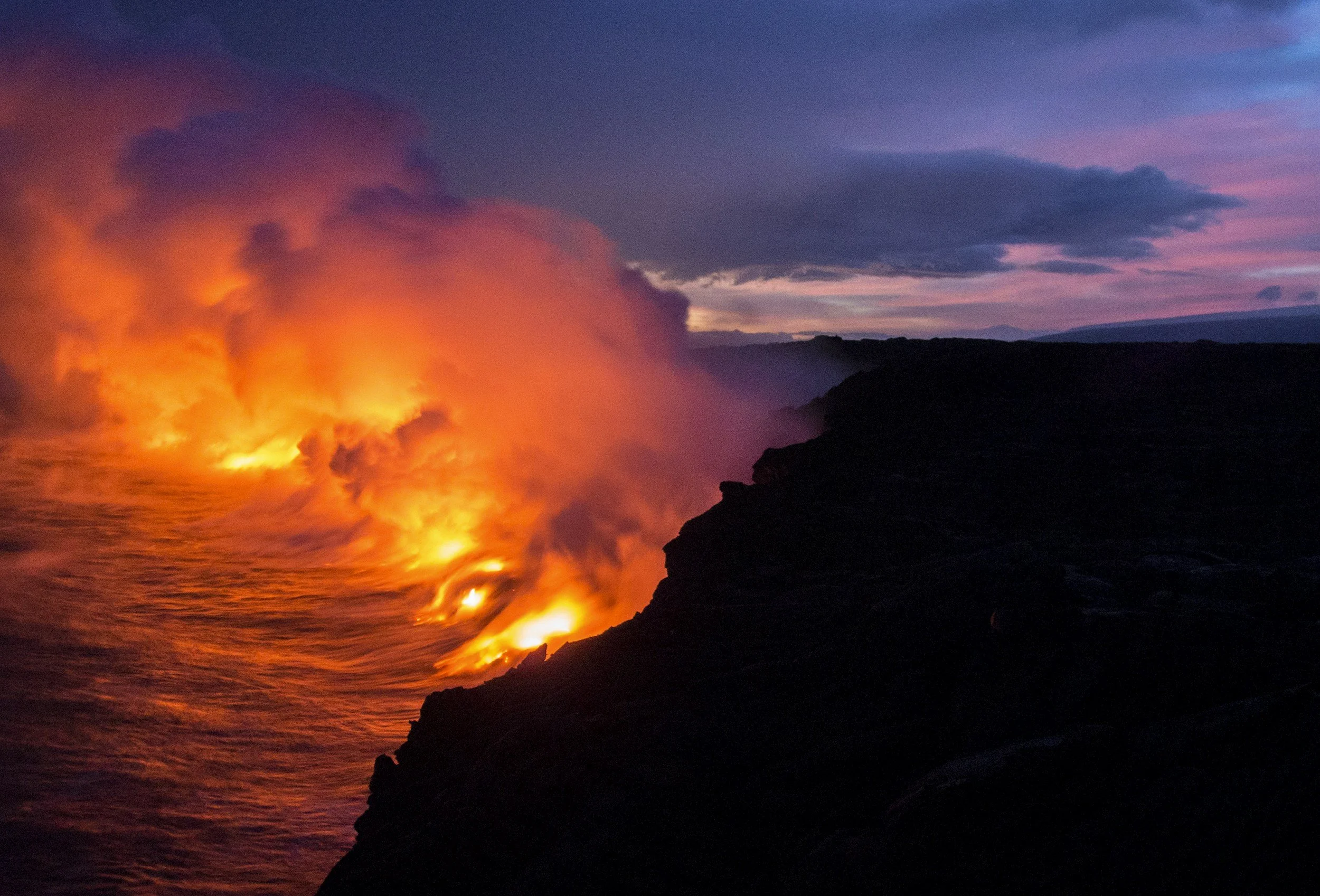 Volcanic fires pour into the ocean, symbolizing the battle between fire and water elements.