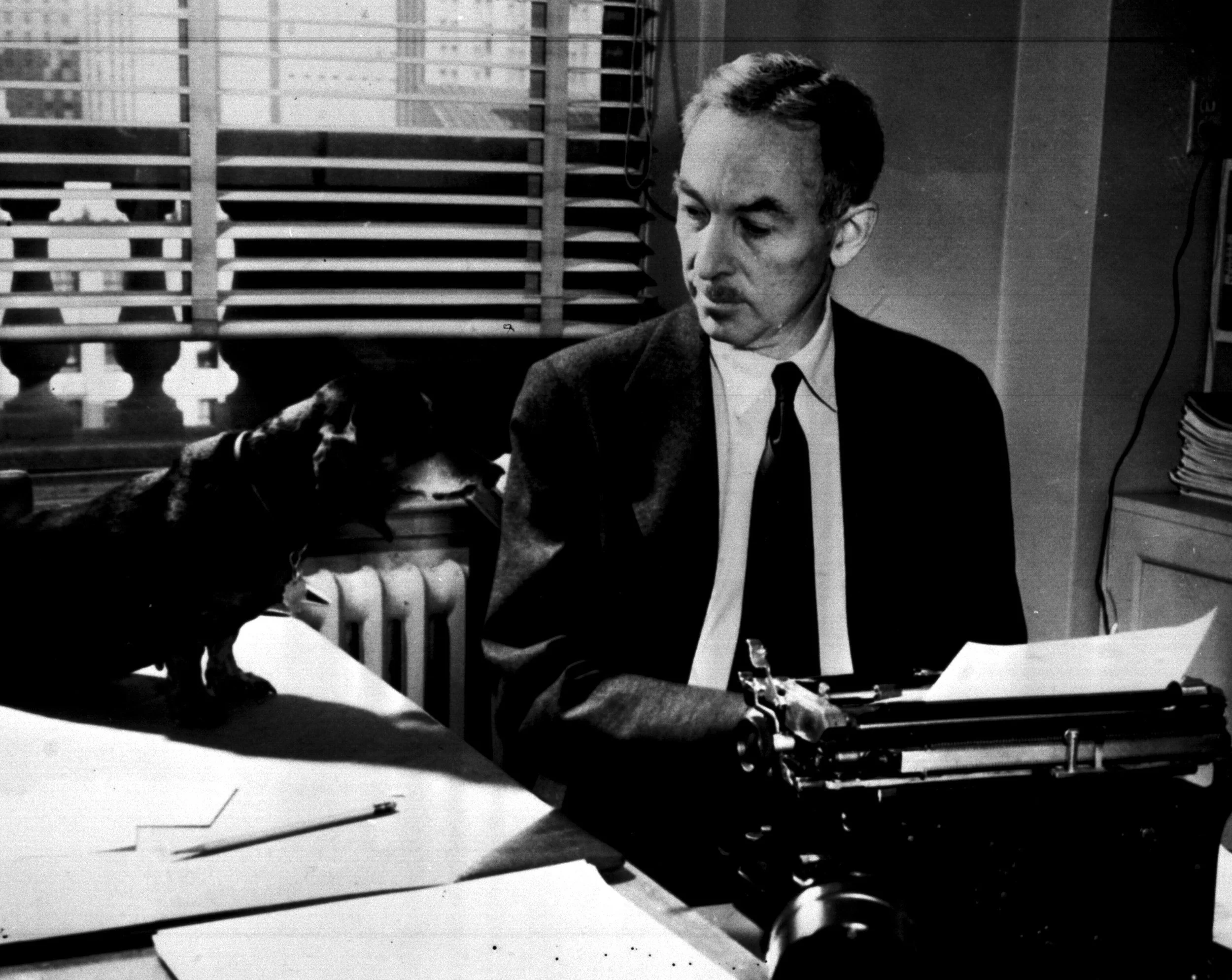 Black and white image of E.B. White, the author, at his desk and typewritter.