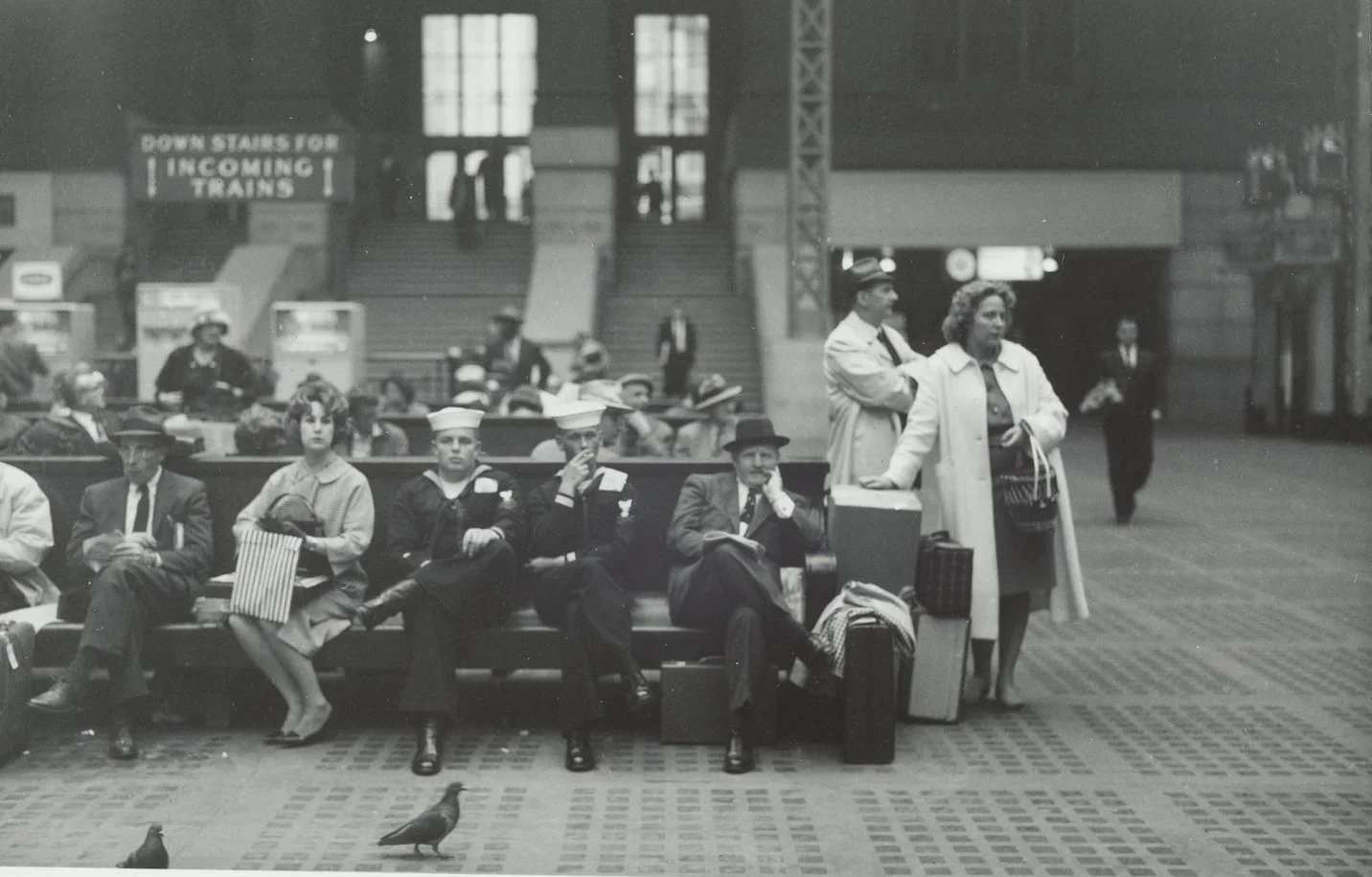 Black and white photo from 1961 of people waiting for train to board at Penn Station in NYC.