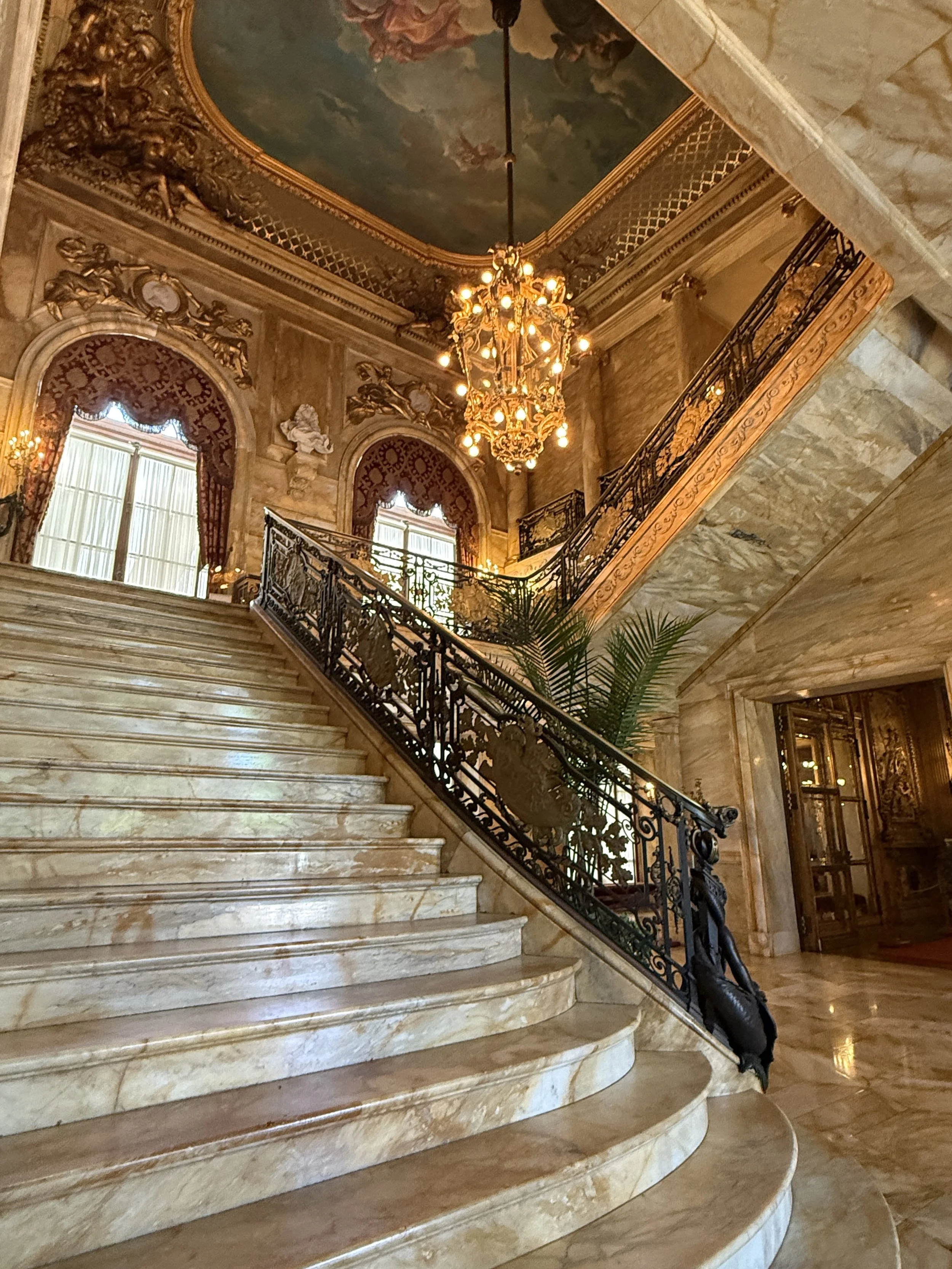 The grand entry marble staircase at Marble House, Newport, Rhode Island with painted ceiling.