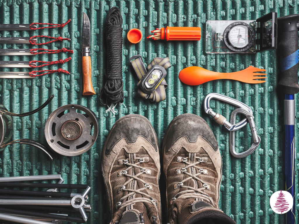 Camping tools laid out on a bed roll, seen from above.
