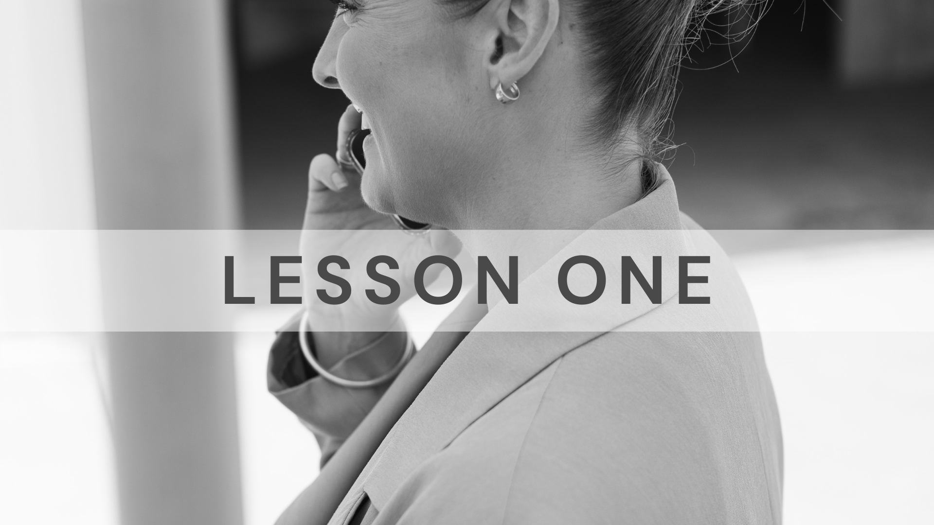 Jarrah Wallace - Kajabi Systems & Automations Partner.  Black and white photo of a woman on the phone, with the text 'Lesson One' overlayed.