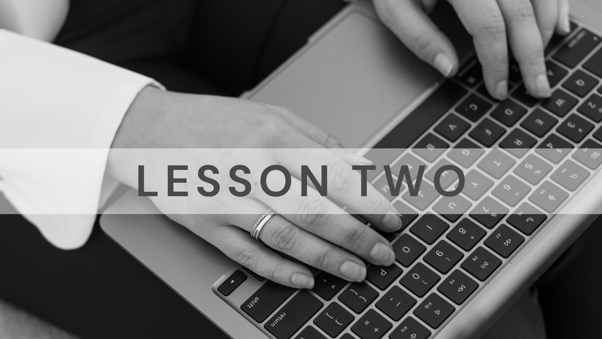 Jarrah Wallace - Kajabi Systems & Automations Partner.  Black and white image of a person's hand using a laptop computer, with the words 'Lesson Two' overlaid.