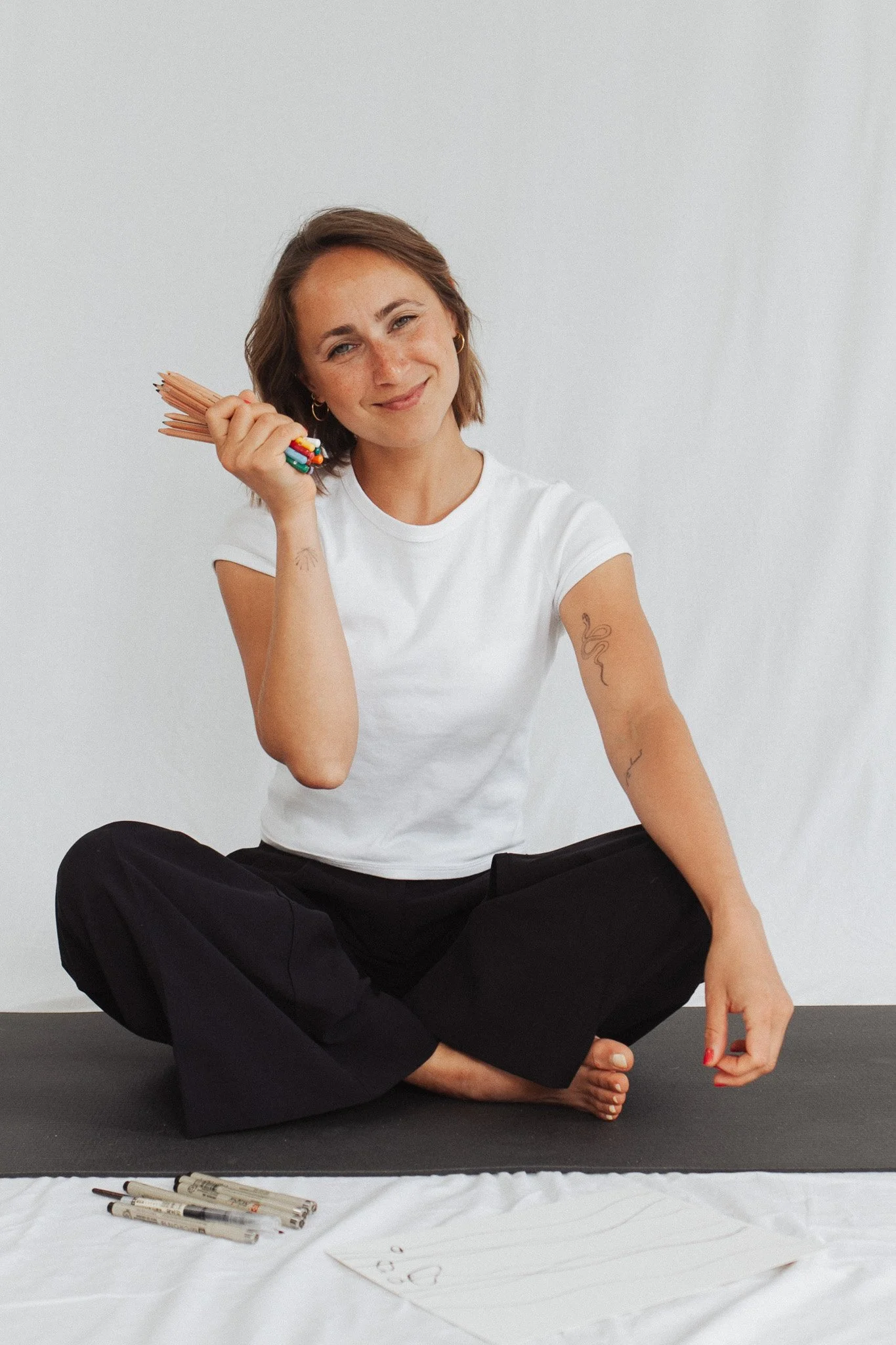 the space holder in seated posotion, holding pencils in her hand.