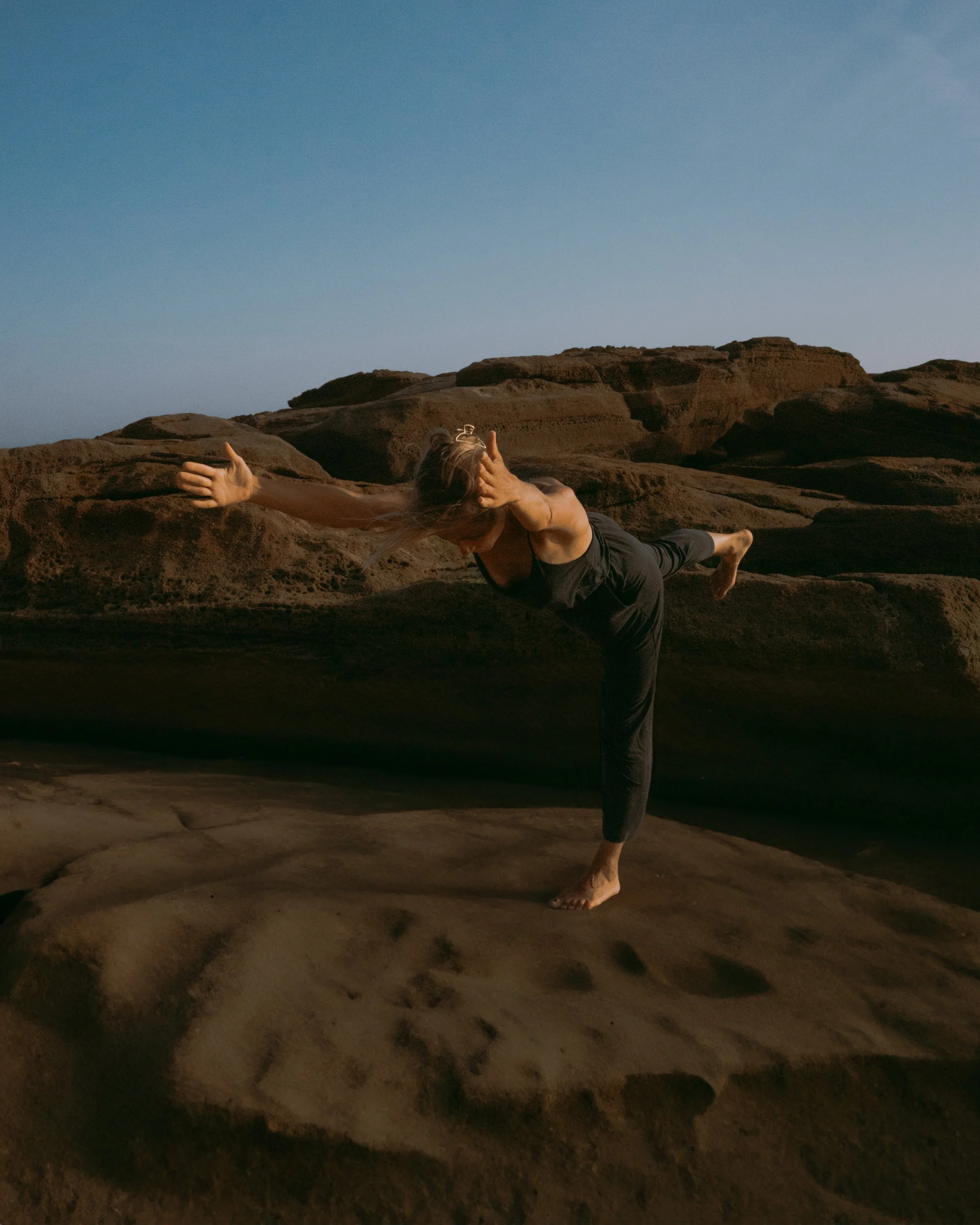 Woman in Yoga Warrior 3 Posture in natural environment