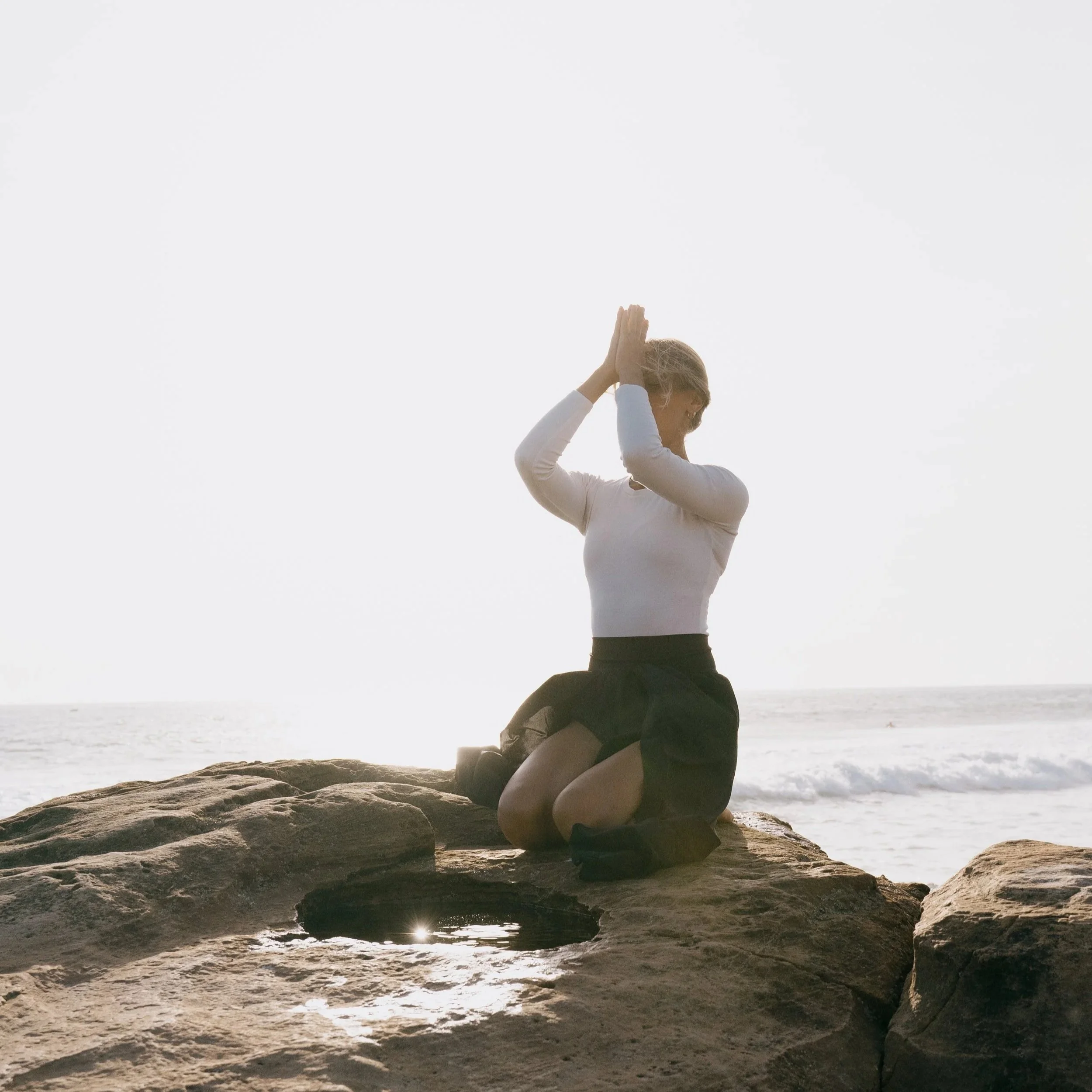 Woman posing in kneeling position and meditating in Nature