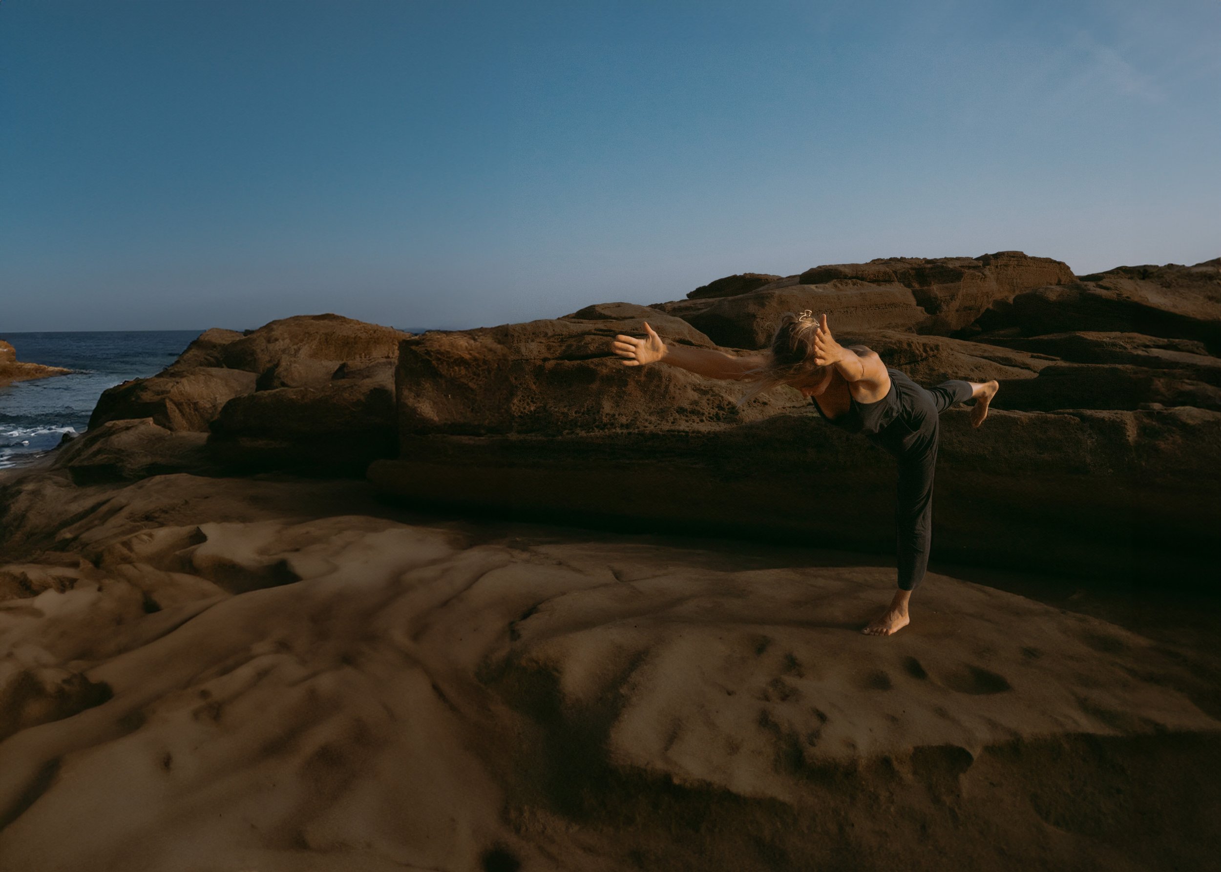 Woman in oceanic nature, posing in a Yoga Asana Warrior 3