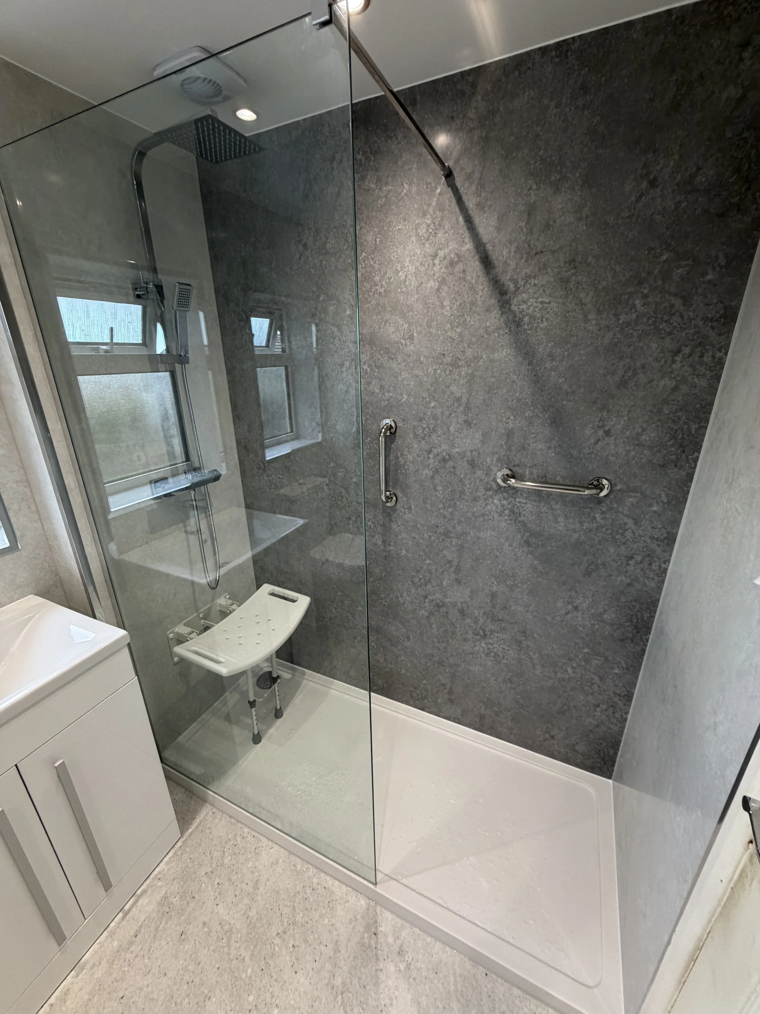 Accessible shower with grab rails and fold-down shower seat
